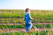 child  in the jeans coverall walk on the dirt road