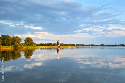 Photo: charming windmill by lake before sunset charming windmill by lake before sunset