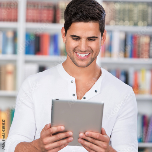 Photo: student liest an seinem tablet-computer student liest an seinem tablet-computer