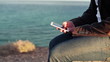 Video: Close up of man`s hands using smartphone by the sea Close up of man`s hands using smartphone by the sea
