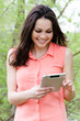 Young happy smiling woman working on pda tablet pc