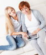 Mother and daughter wiht tablet at sofa