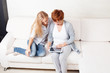 Mother and daughter wiht tablet at sofa