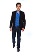 Walking young business man wearing blue jacket and jeans. Isolat
