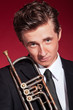 Retro fifties trumpet player wearing black suit and tie. Holding