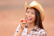 American cowgirl eating peach smiling happy