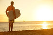 Surfer man on beach at sunset holding bodyboard Surfer man on beach at sunset holding bodyboard