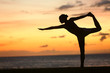 Photo: Yoga woman in serene sunset at beach doing pose Yoga woman in serene sunset at beach doing pose