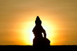 Sitting Buddha against rising sun