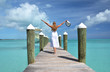 Girl on the wooden jetty looking to the ocean. Exuma, Bahamas