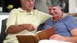 Mature couple laughing while looking at a book 