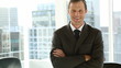 Smiling businessman standing by window
