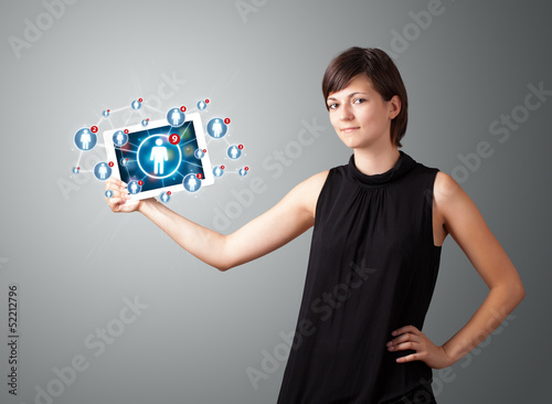 Photo: young woman holding tablet with social network icons young woman holding tablet with social network icons