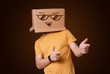 Young man gesturing with a cardboard box on his head with smiley
