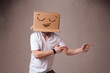 Young man gesturing with a cardboard box on his head with smiley