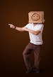 Young man gesturing with a cardboard box on his head with smiley
