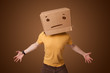 Young man gesturing with a cardboard box on his head with straig