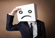 Photo: Businessman gesturing with cardboard box on his head with sad fa Businessman gesturing with cardboard box on his head with sad fa