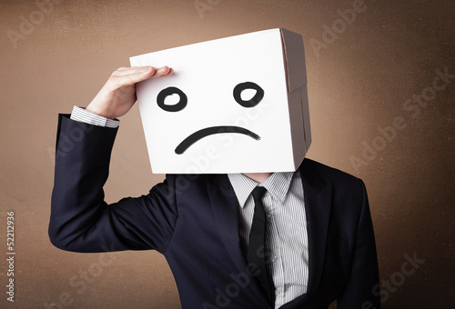 Photo: Businessman gesturing with cardboard box on his head with sad fa Businessman gesturing with cardboard box on his head with sad fa