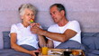 Elderly couple having breakfast in bed