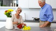 Woman arranging flowers and holds one to husbands nose