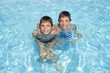 two happy friends swimming in the pool