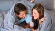 Couple having fun wrapped in their duvet