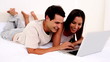 Delighted couple using a laptop