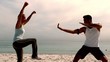 Athletes doing martial arts on the beach