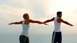 Man and woman doing pilates on beach