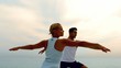 Man and woman doing yoga on beach