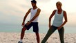 Man and woman doing pilates on beach together