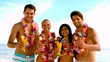 Friends wearing garlands and enjoying cocktails on the beach