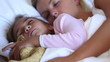 Mother and daughter cuddling in bed