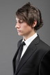 young businessman black suit casual tie on gray background