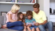 Family on the couch looking at tablet pc