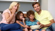 Family eating popcorn and watching tv together