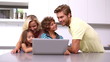 Family looking at laptop in kitchen