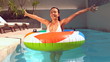 Pretty woman emerging from underwater into rubber ring in pool