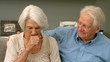 Old woman coughing next to her husband