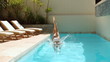 Attractive brunette diving into swimming pool