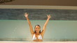 Attractive woman jumping and raising her hands
