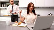 Woman calling her partner to look at laptop at breakfast
