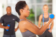 side view of african american woman lifting dumbbell