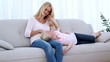 Daughter resting on mothers lap and playing with her hair