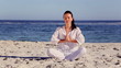 Brunette woman meditating in sukhasana pose
