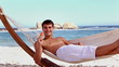 Attractive man eating ice lolly in a hammock