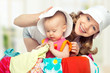 Mom and baby girl with suitcase and clothes ready for traveling