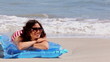 Girl sunbathing on a lilo on the beach