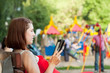 woman reads e-book against  playground area